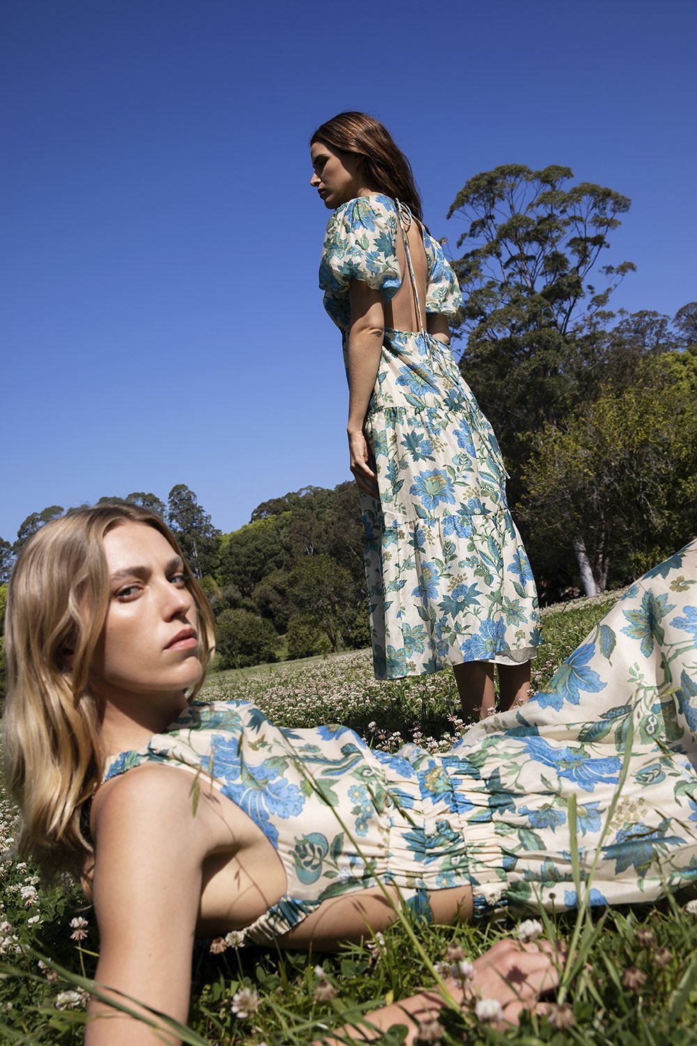 Models posing in grass with blue sky