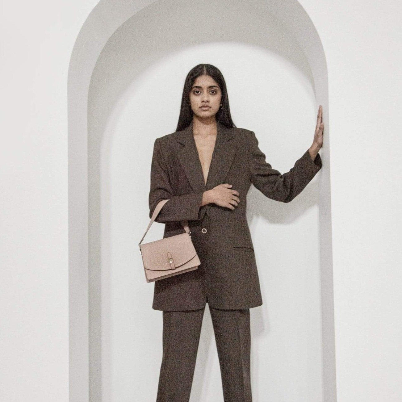Model in suit holding bag