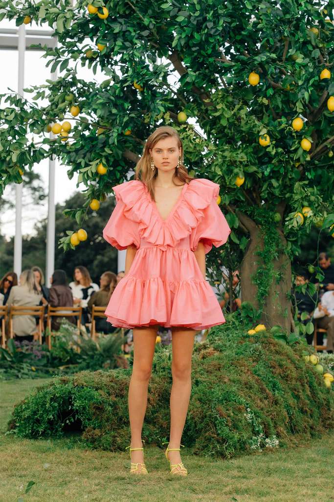 Model posing in front of lemon tree in dress