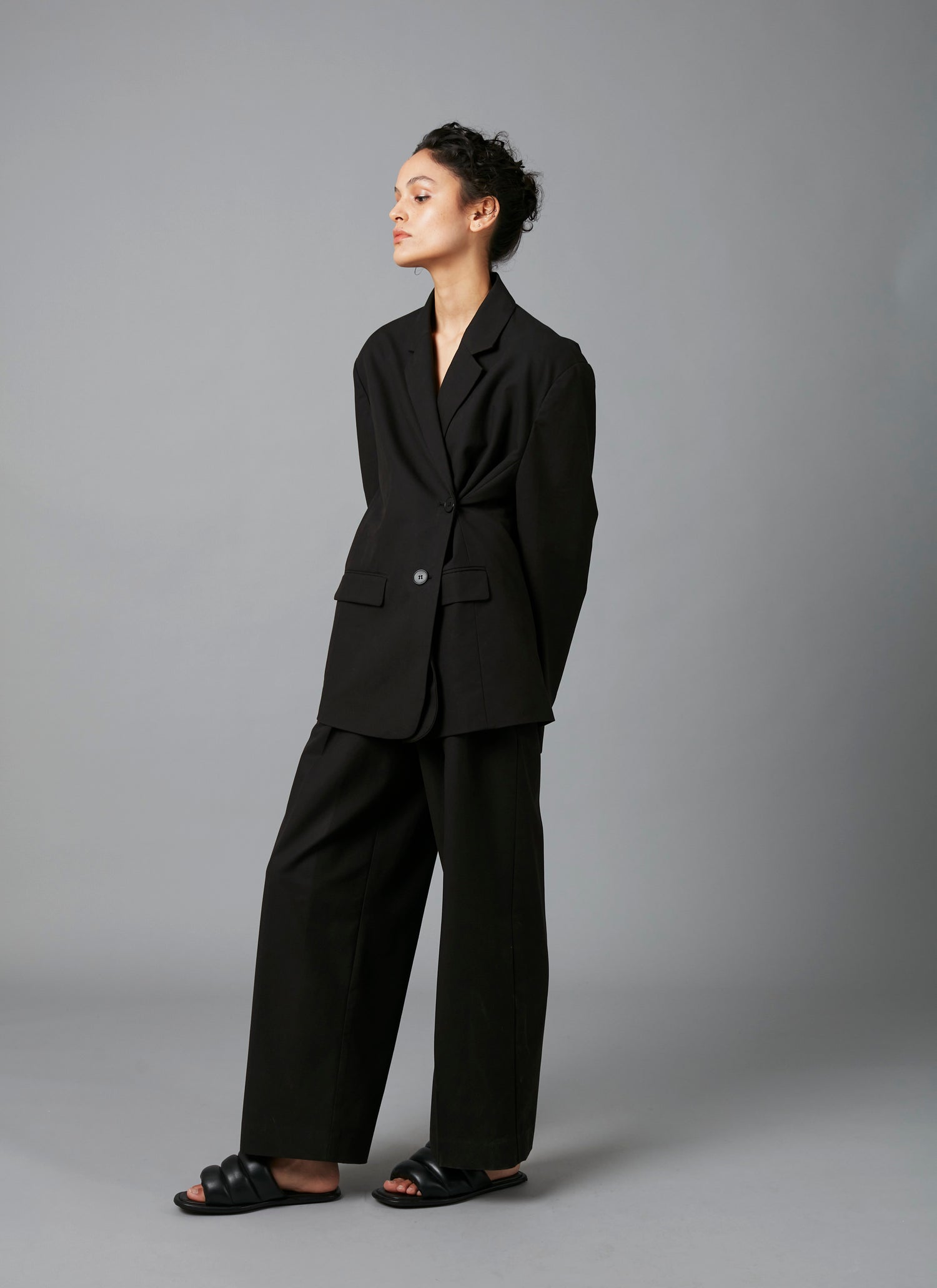 Model in black suit of Black Lita Oversized Cotton Tencel Tailored Jacket  and Black Sculpture Cotton Tencel Pants
