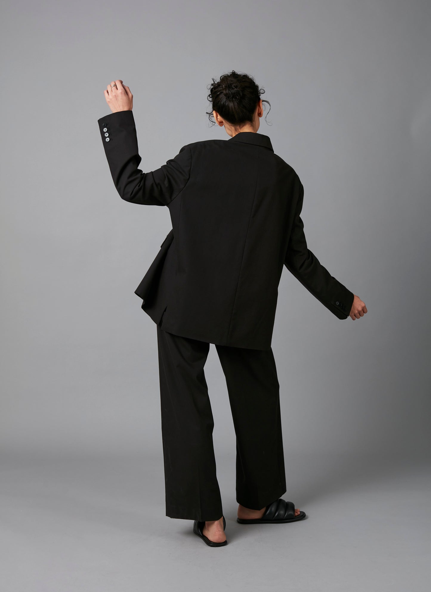 Model back view dancing in Black Lita Oversized Cotton Tencel Tailored Jacket  and  Black Sculpture Cotton Tencel Pants